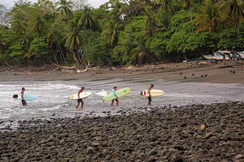 Surfeurs avec leurs planches sur une plage d’Amérique centrale
