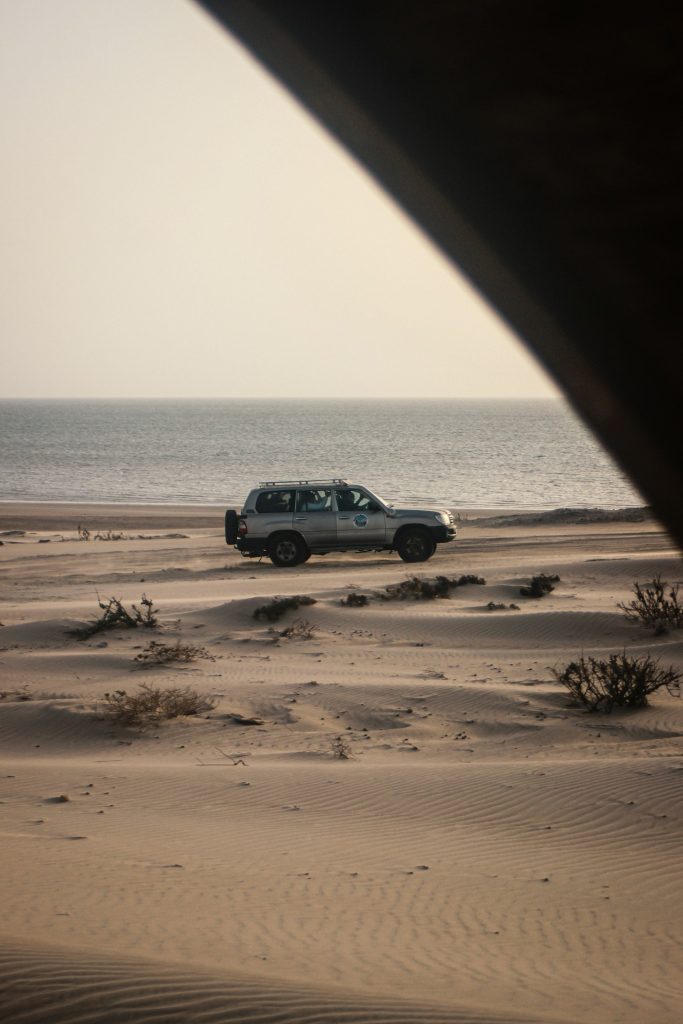 4x4 sur une plage entre désert et océan à Dakhla