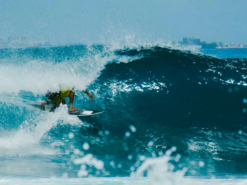Surfeur sur une vague aux Maldives